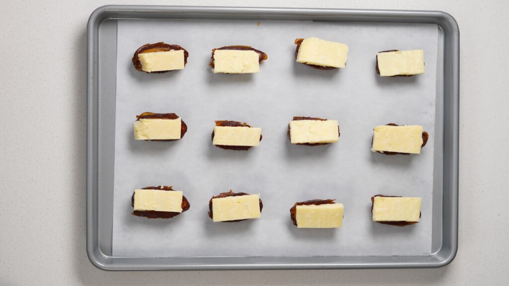 Sliced dates with cheddar on baking tray