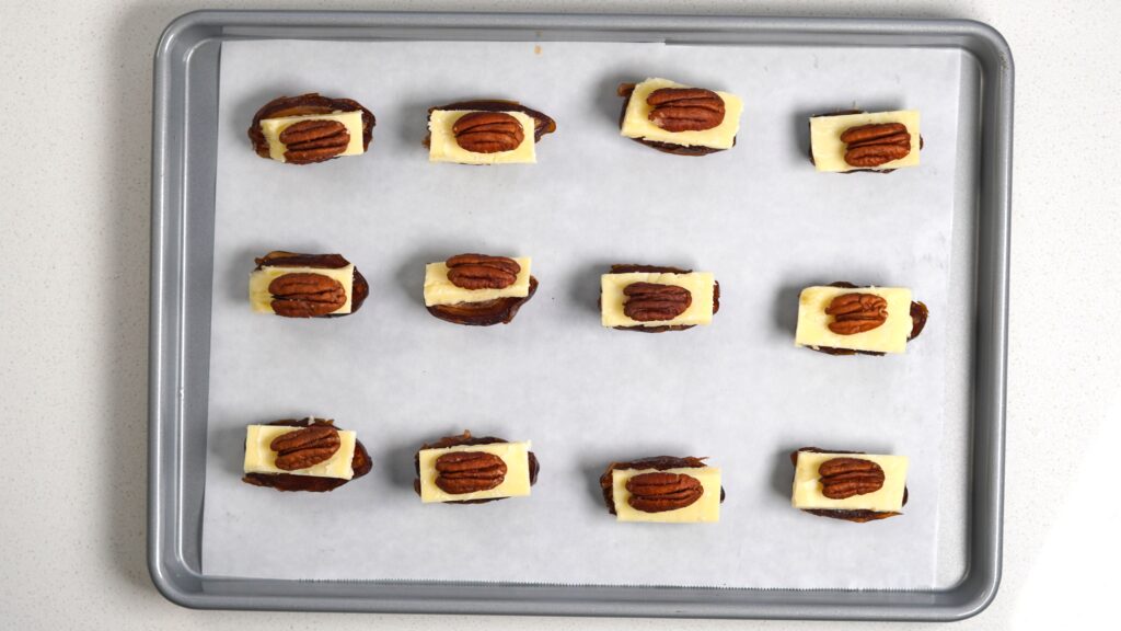 Sliced dates with cheddar and pecans on a tray