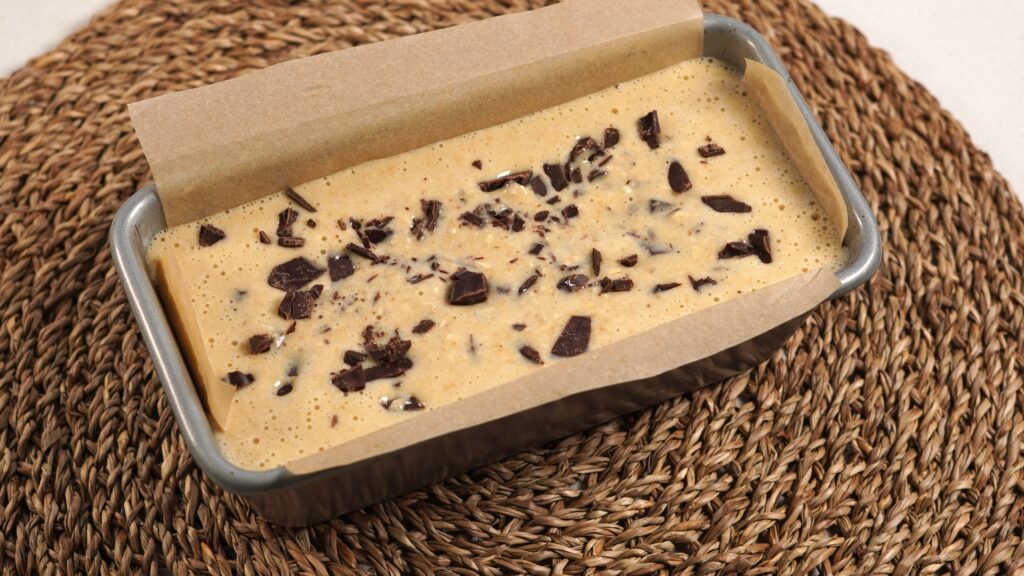 Banana bread batter with chocolate chips in a loaf tin
