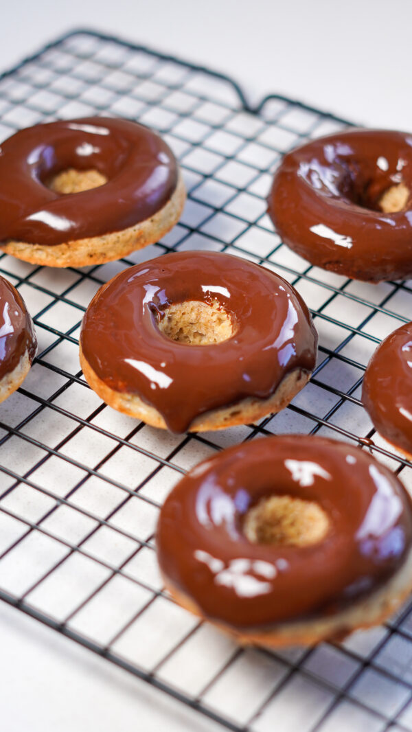 Healthy chocolate banana doughnuts on a cooling rack