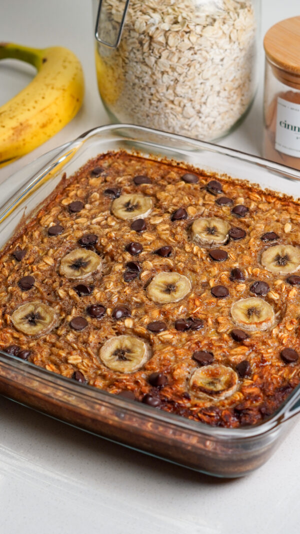 One pan banana baked oats in a baking dish with sliced banana and chocolate chips on top