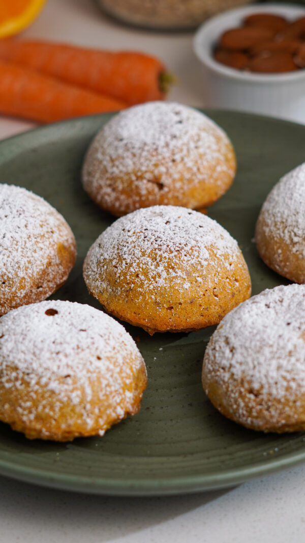 Mini carrot cakes on green plate shaped like Camille with a dusting of icing sugar on top.