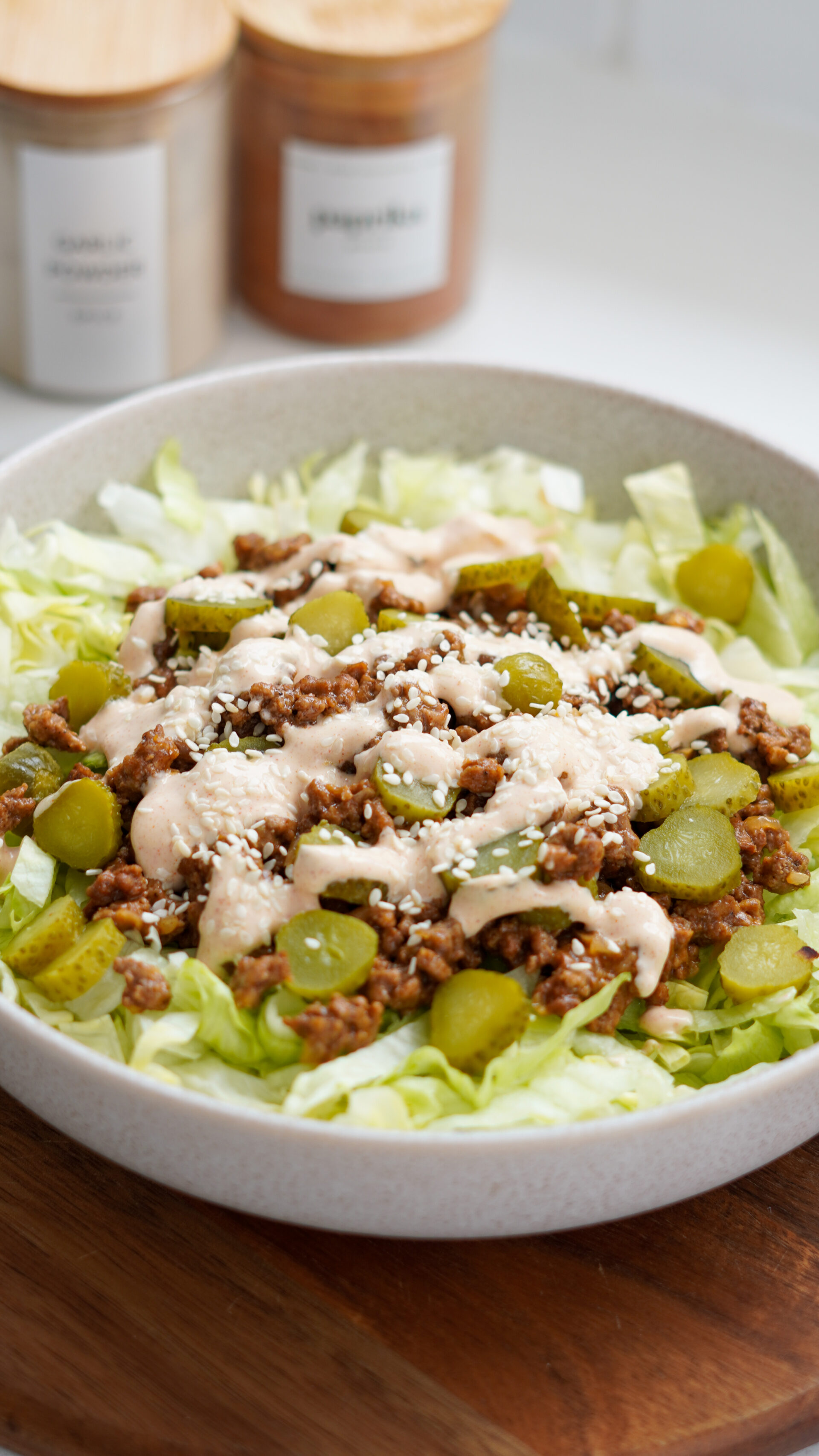 Big Mac Salad served in a bowl with lettuce, cheesy beef mince, sliced pickles, and yoghurt burger sauce, sprinkled with sesame seeds – a low-carb, high-protein meal.