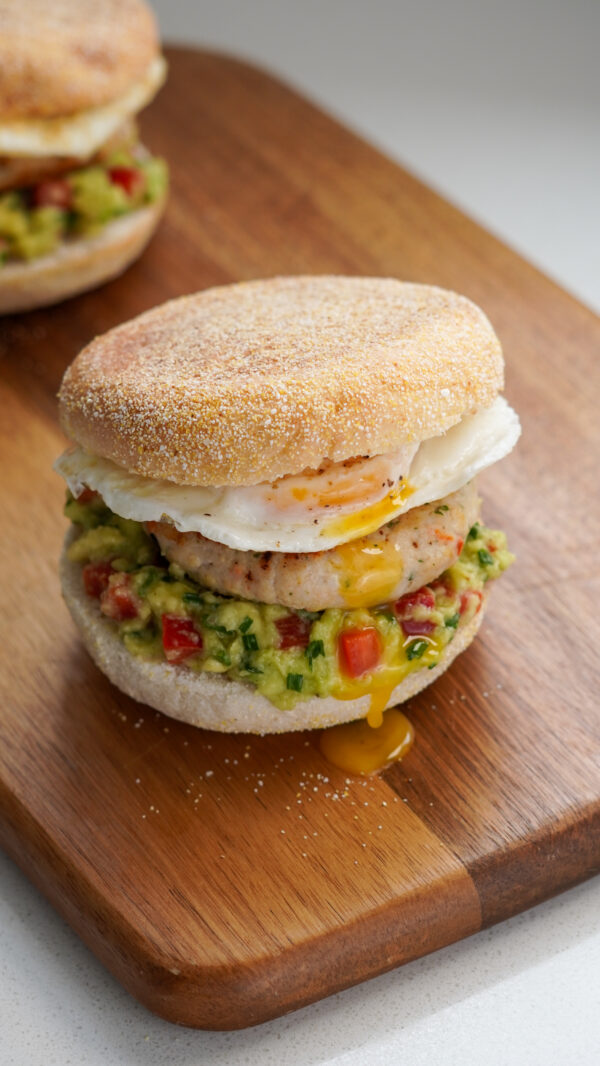 Chicken Sausage English Muffin with herby chicken patty, mashed avocado salsa, fried egg, and soft muffin – a healthy high-protein breakfast.